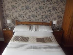 1 dormitorio con 1 cama con 2 mesitas de noche y 2 lámparas en Tudor House, en Great Yarmouth