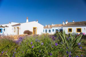 拉古什的住宿－Casas da Capela do Monte, Country Houses，一群白色的房屋,花紫色