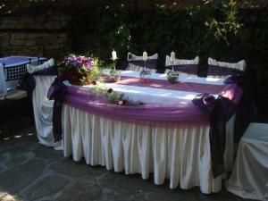 a purple and white table with flowers and candles at Oazis Family Hotel in Lovech