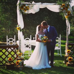 une mariée et un marié embrassant sous une arche de mariage dans l'établissement Lavender Hill, Eko Resort & Wellness, à Polzela