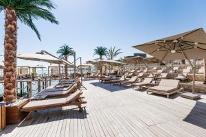 a deck with lounge chairs and umbrellas at a resort at Lords Palace Hotel SPA Casino in Kyrenia