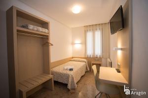 a hotel room with two beds and a television at Hostal Aragón in Teruel