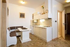 a small white kitchen with a table and a counter at Chopok juh Apartman Vanda in Tale