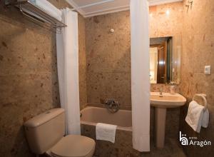 a bathroom with a toilet and a sink and a tub at Hostal Aragón in Teruel