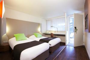 a hotel room with two beds and a sink at Campanile Rouen Est - Franqueville Saint Pierre in Franqueville-Saint-Pierre +26 photos