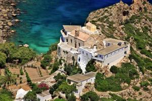 a large house on a cliff next to the ocean at Casa D'armaros in Kissamos