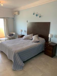 1 dormitorio con 1 cama grande y cabecero grande en Loft N1 con vista al mar en Las Grutas