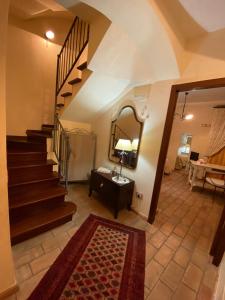 pasillo con escalera con espejo y alfombra en B&B L'Antica Balbia en Altomonte