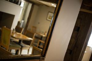 een spiegel met een tafel en een eetkamer bij The Kings Head in New Buckenham