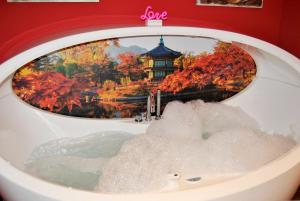 una bañera con una foto de un japanbiddenbiddenbiddenbiddenbidden en Apartamentos DELUXE Con Jacuzzi o Chimenea LOVE FOR TWO en Collado Mediano