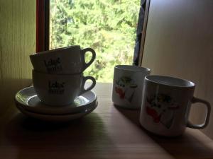 three coffee cups sitting on a window sill at Dotik gozda in Železniki