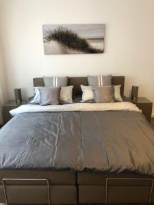 - une chambre avec un grand lit et des oreillers dans l'établissement Apartments City Center Düsseldorf, à Düsseldorf