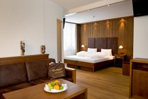 a hotel room with a bed and a bowl of fruit on a table at Hotel Quellenhof Leukerbad in Leukerbad