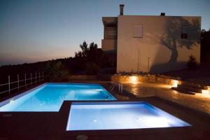 una piscina frente a una casa por la noche en Paterakis Studios Triopetra, en Triopetra