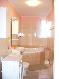 y baño con bañera, aseo y lavamanos. en Apartman Nadezda, en Karlovy Vary