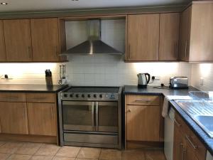 a kitchen with wooden cabinets and a stove top oven at Little Hermitage in Detling +6 photos