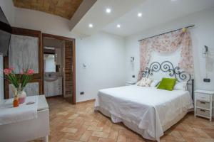 a bedroom with a large white bed and a bathroom at Cà Reginella B&B in Diano dʼAlba