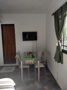 a dining room with a table and chairs and a television at Alojamiento Entero con Excelente Ubicación in Morón