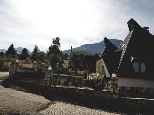 a house with a black roof next to a fence at Vila Piramida in Bitola