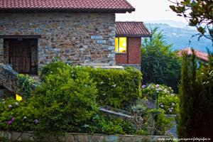 una casa in pietra con un giardino di fronte di Txerturi-Goikoa a Itziar
