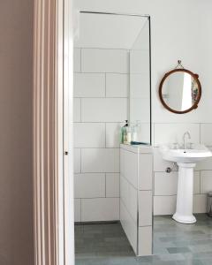 a white bathroom with a sink and a mirror at Boscobel of Tasmania in Ulverstone