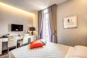 Cette chambre comprend un lit, une table et un bureau. dans l'établissement Roma Boutique Hotel, à Rome