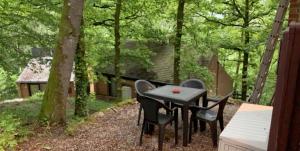 een tafel en stoelen op een patio in het bos bij Wood House in Blaimont