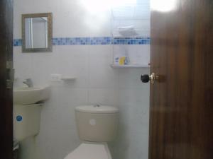 a bathroom with a toilet and a sink and a mirror at Posada Miss Joyce House in San Andrés