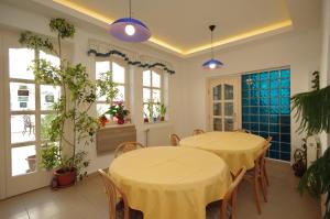 two tables in a room with windows and plants at Csigaház in Gyula