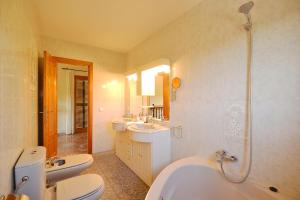 ein Badezimmer mit zwei Waschbecken und einer Badewanne und einer Toilette in der Unterkunft Caricuao house in Plamanyola