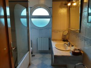 a bathroom with a sink and a window at Chalet Avila Rooms in Madrid