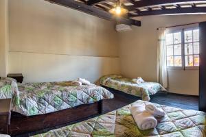 a room with three beds and a window at APART LA VIÑA in Salta