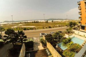 Blick auf einen Parkplatz mit einem Auto, das eine Straße entlangfährt in der Unterkunft MANDAI - Cabo Frio - RJ in Cabo Frio