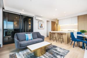 a living room with a couch and a table at Sky One Apartments by CLLIX in Box Hill