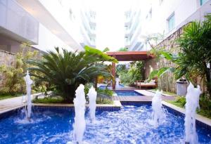 ein Schwimmbad mit weißen Fontänen in einem Gebäude in der Unterkunft MANDAI - Cabo Frio - RJ in Cabo Frio + 28 Fotos