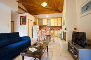 sala de estar con sofá azul y mesa en Villa Elli 2 Beach-front villa with garden, en Itea