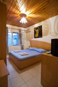 a bedroom with a bed with a wooden ceiling at Villa Elli 2 Beach-front villa with garden in Itea