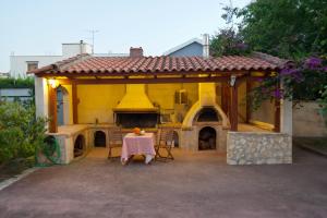 a yellow house with a table and a fireplace at Villa Elli 2 Beach-front villa with garden in Itea