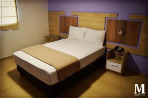 En eller flere senger på et rom på Hotel Mega