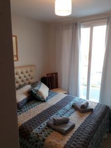 ein Schlafzimmer mit einem Bett mit zwei Hausschuhen darauf in der Unterkunft CALIDO-Departamento 1 dormitorio amueblado excelente ubicacion in Río Cuarto