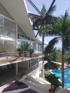 a building with a swimming pool and a palm tree at PuntaGaviota in Santa Cruz Huatulco