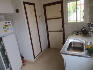 a kitchen with a sink and a refrigerator at Chalet Ymaz in Villa Gesell +15 photos