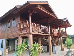 a large wooden house with a large balcony at Life and Love house in Ban Na Noi