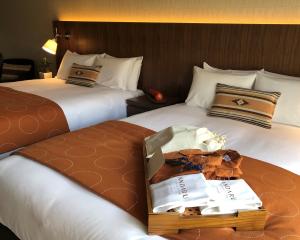 um quarto de hotel com duas camas e uma mesa com copos em Andaru Collection Niseko em Kutchan