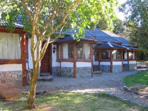 una casa con un árbol delante de ella en Ayres del Lago en San Carlos de Bariloche