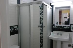a white bathroom with a sink and a shower at Casa Posada Amelia in Bogotá +85 photos