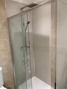 a shower with a glass door in a bathroom at Dunfermline GF flat, 5 min walk to Train St. and High St. in Dunfermline