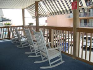 a patio area with chairs, tables, and tables with umbrellas at Beach Walk Hotel in Ocean City