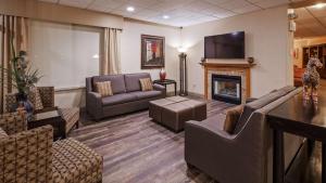 a living room with a couch and a fireplace at Best Western Crossroads of the Bluffs in Council Bluffs