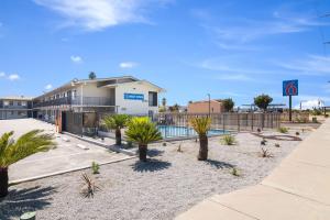 a parking lot with palm trees in front of a building at Motel 6-Moreno Valley, CA - Perris in Moreno Valley